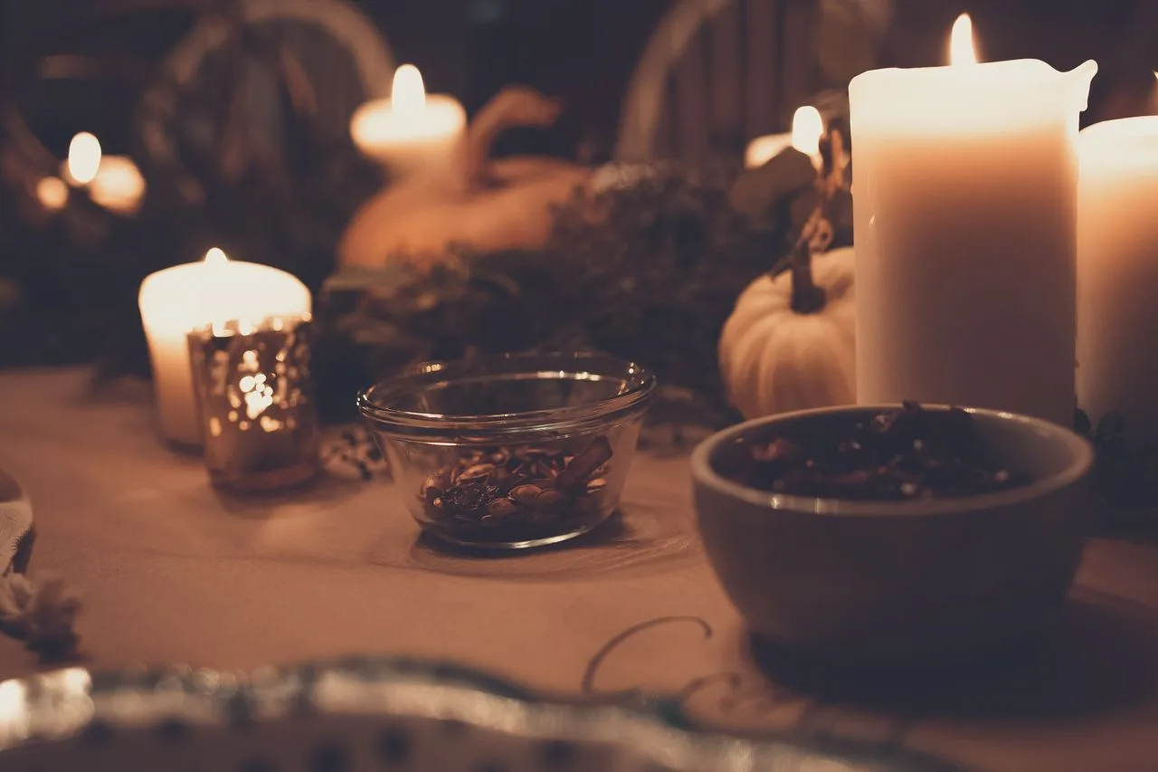 Warm autumn table with pillar candles, bowls and small pumpkins