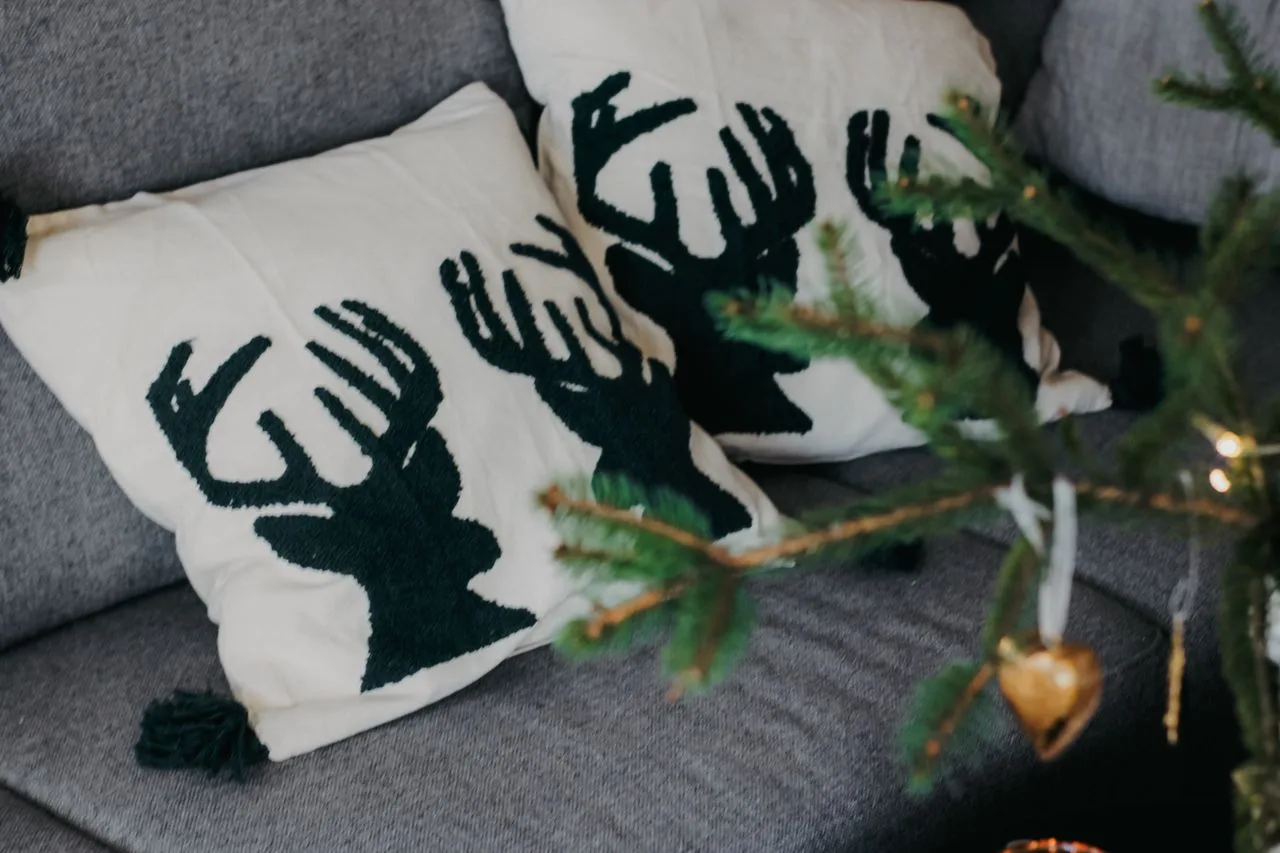 Festive reindeer cushions styled on a sofa for Christmas