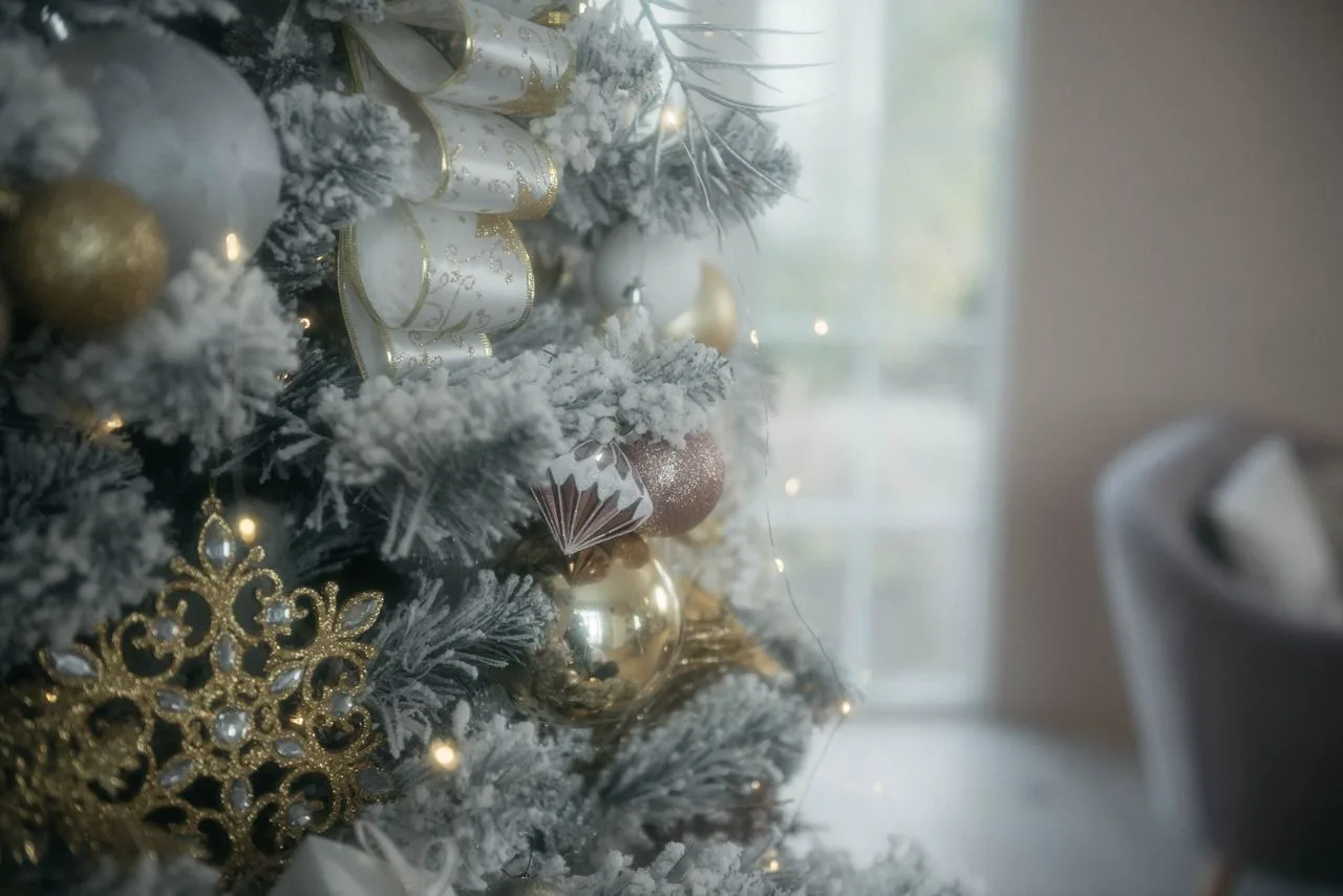 Christmas tree decorated with gold and white ornaments and ribbon