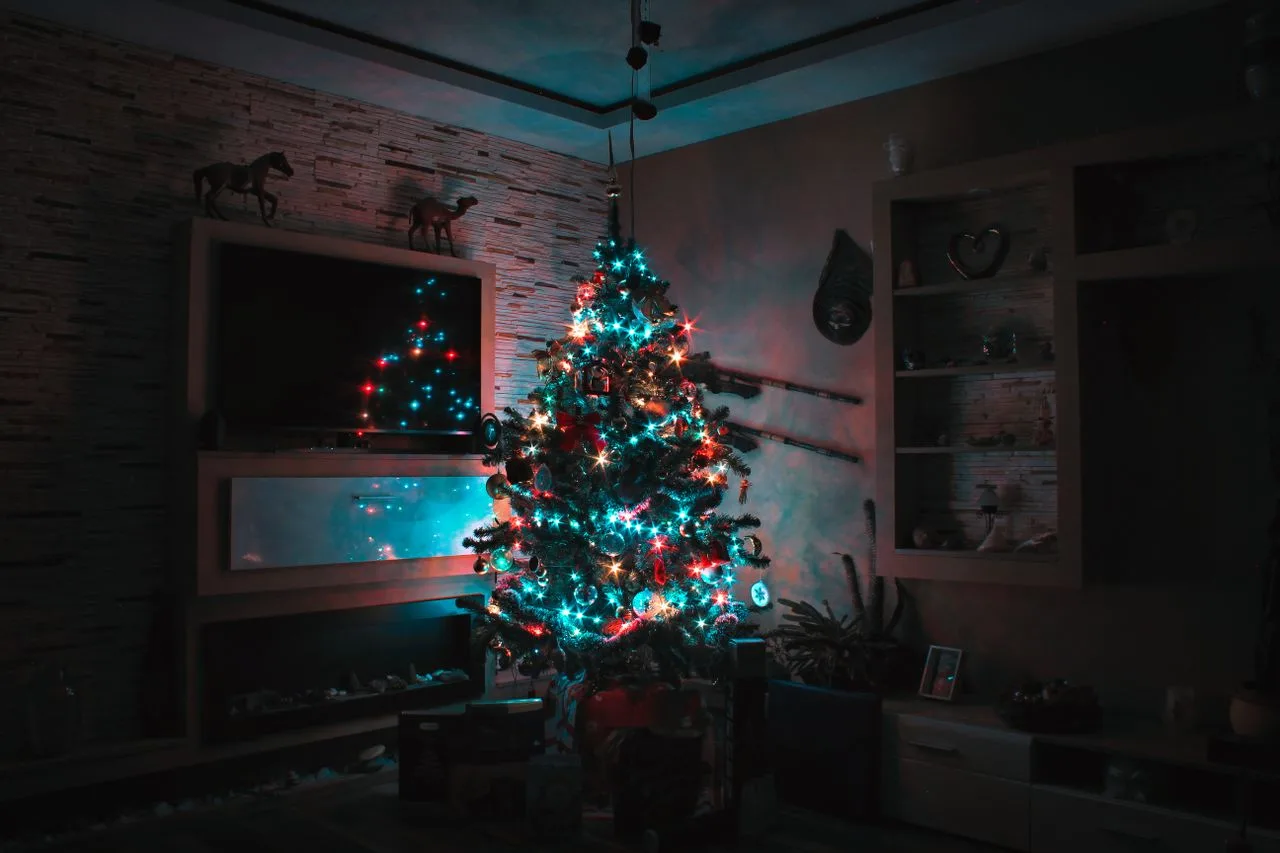 Christmas tree glowing with warm lights in a living room at night