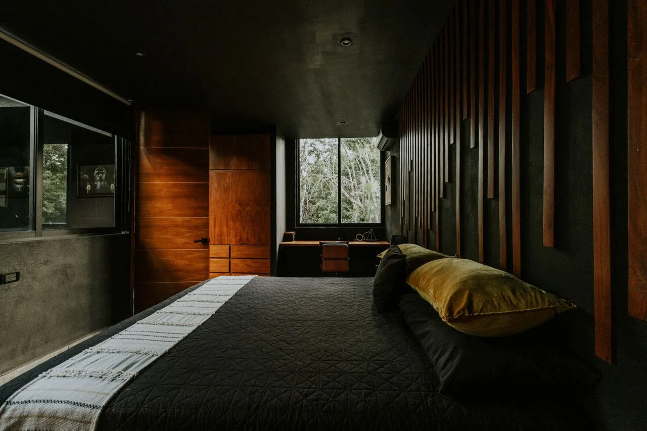 Dark bedroom with wood panel accents and a low bed
