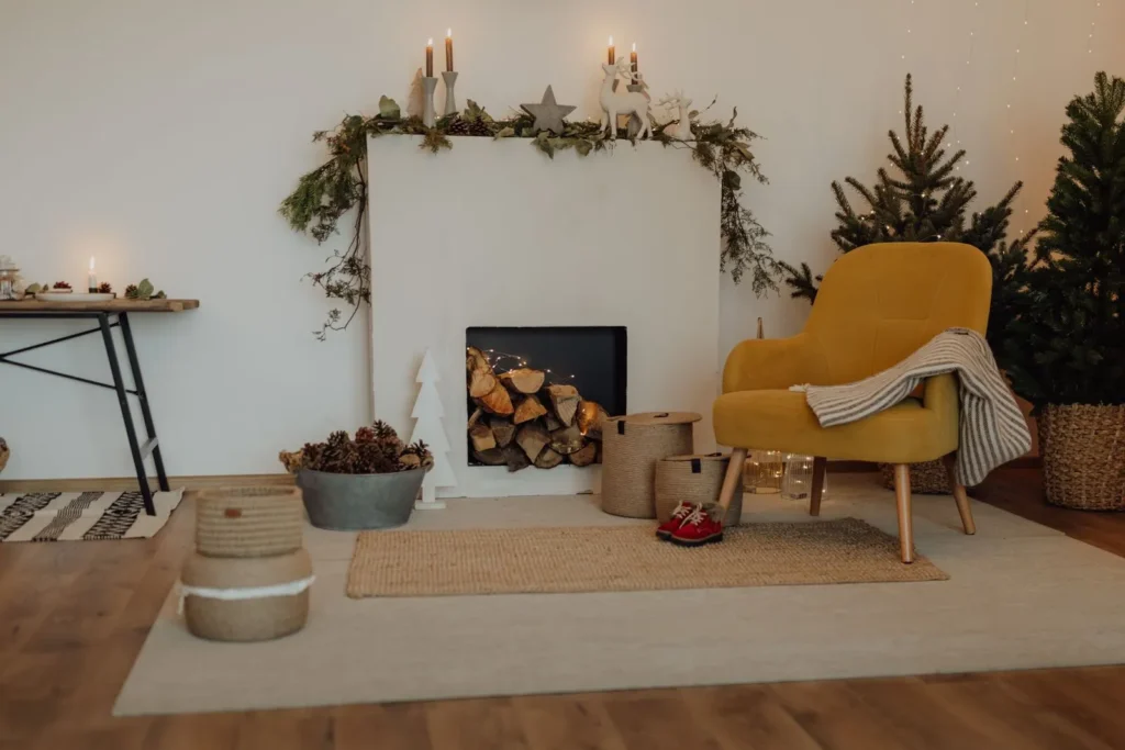 Faux Christmas mantel with a loose garland, taper candles and stacked logs in a non-working fireplace