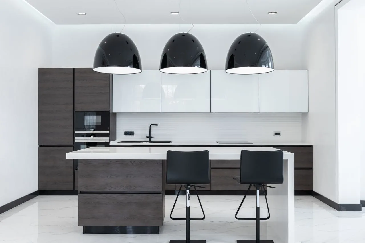 Spacious minimalist kitchen with pendant lights over a dining table