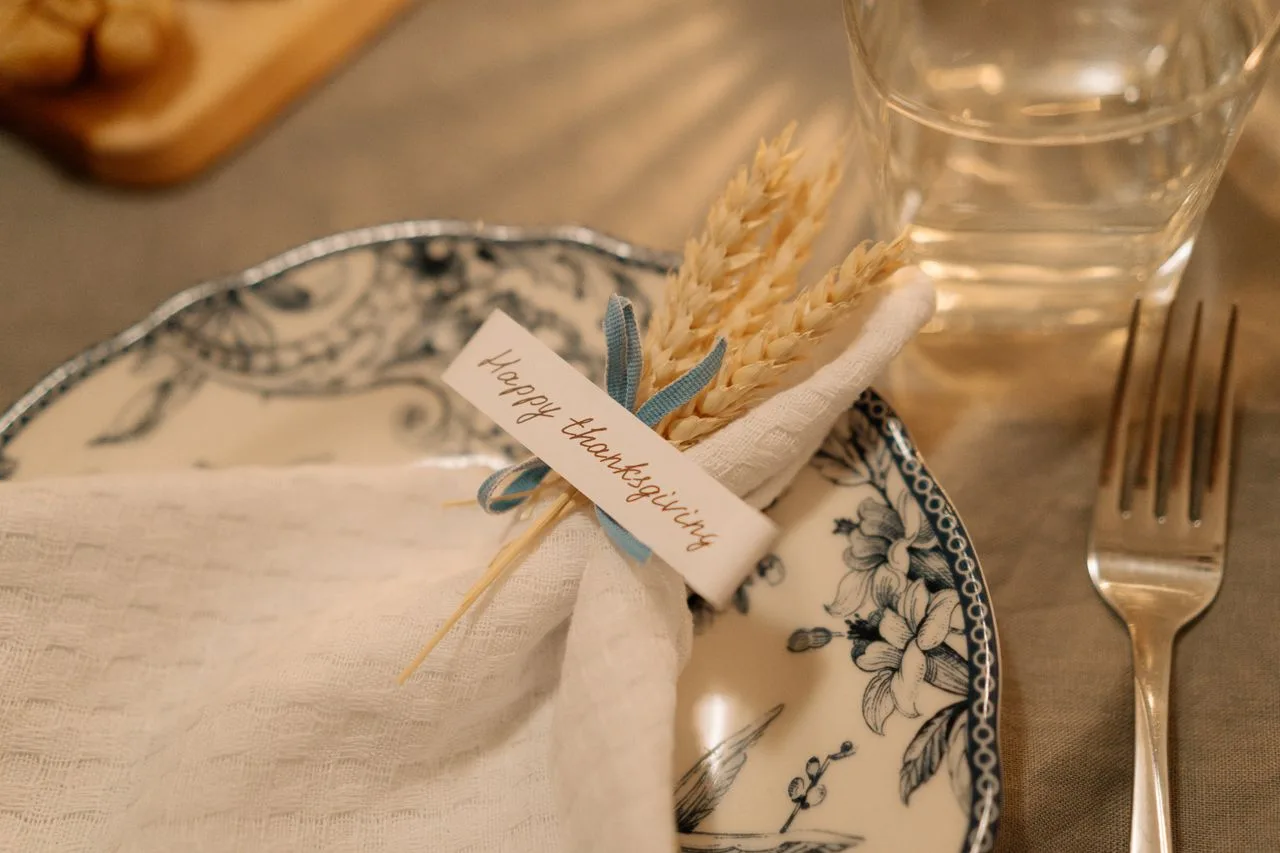 Thanksgiving place setting with a patterned plate and wheat-tied napkin